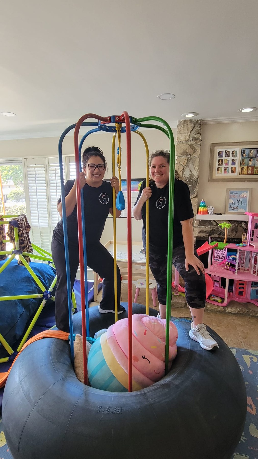 Olivia Martinez-Hauge and Amanda Staples standing within a custom sensory structure during a residential installation.