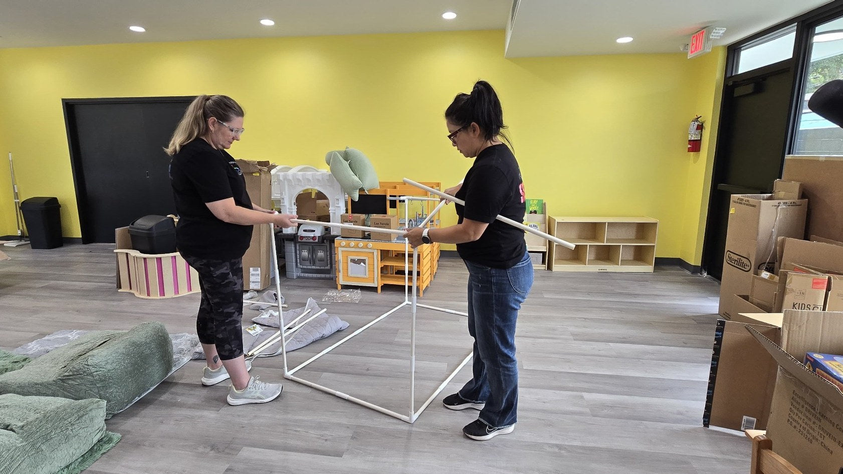 Olivia Martinez-Hauge and Amanda Staples assembling a custom sensory structure during installation.